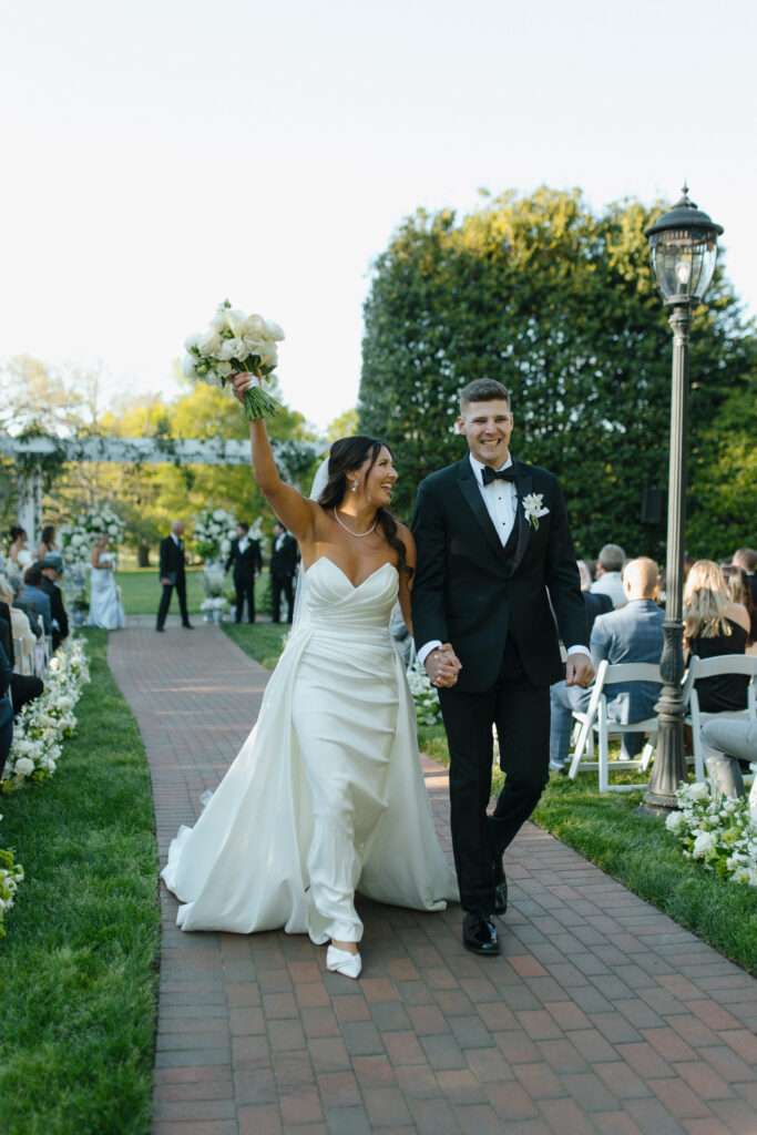 Bride and groom following their ceremony walking back down the isle smiling at each other
