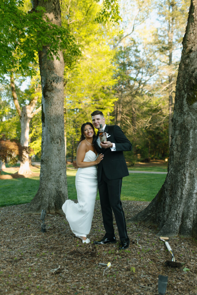 boxwood estate tradition of burring the bourbon. Bride and groom showing off the bottle of bourbon.