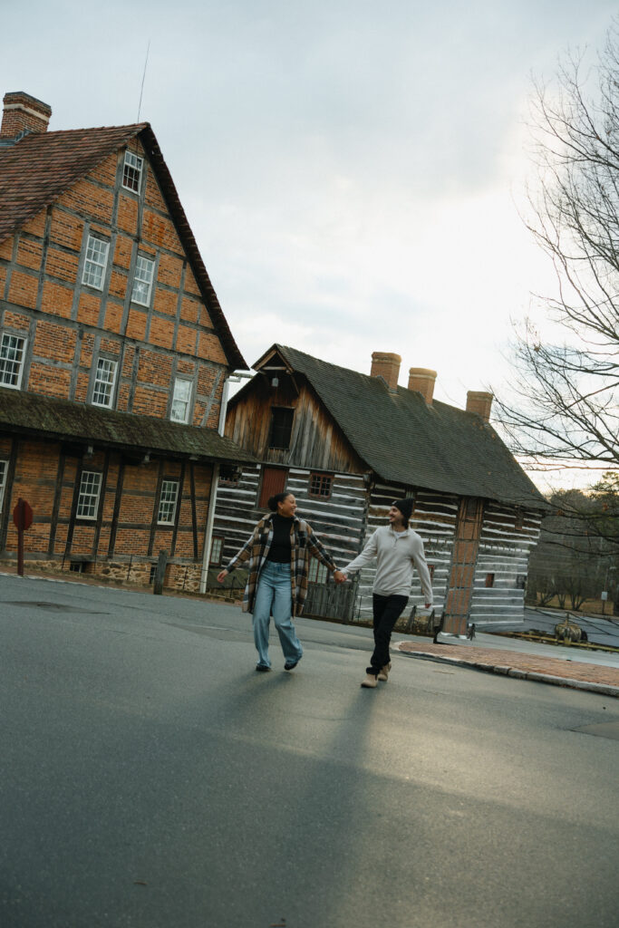 couple holding hands running across the street