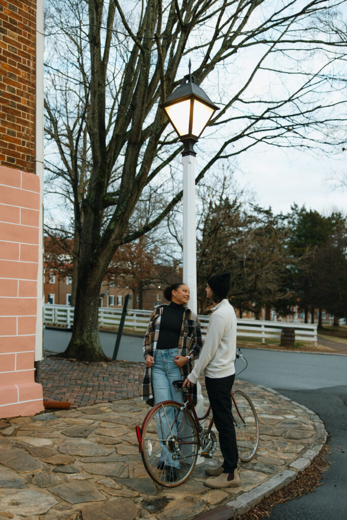 gril leaned up against the light pole looking over at her boyfriend