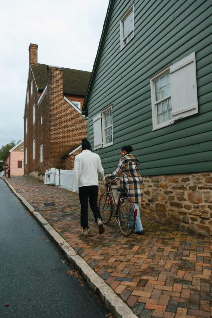 couple walking down the sidewalk with a bike